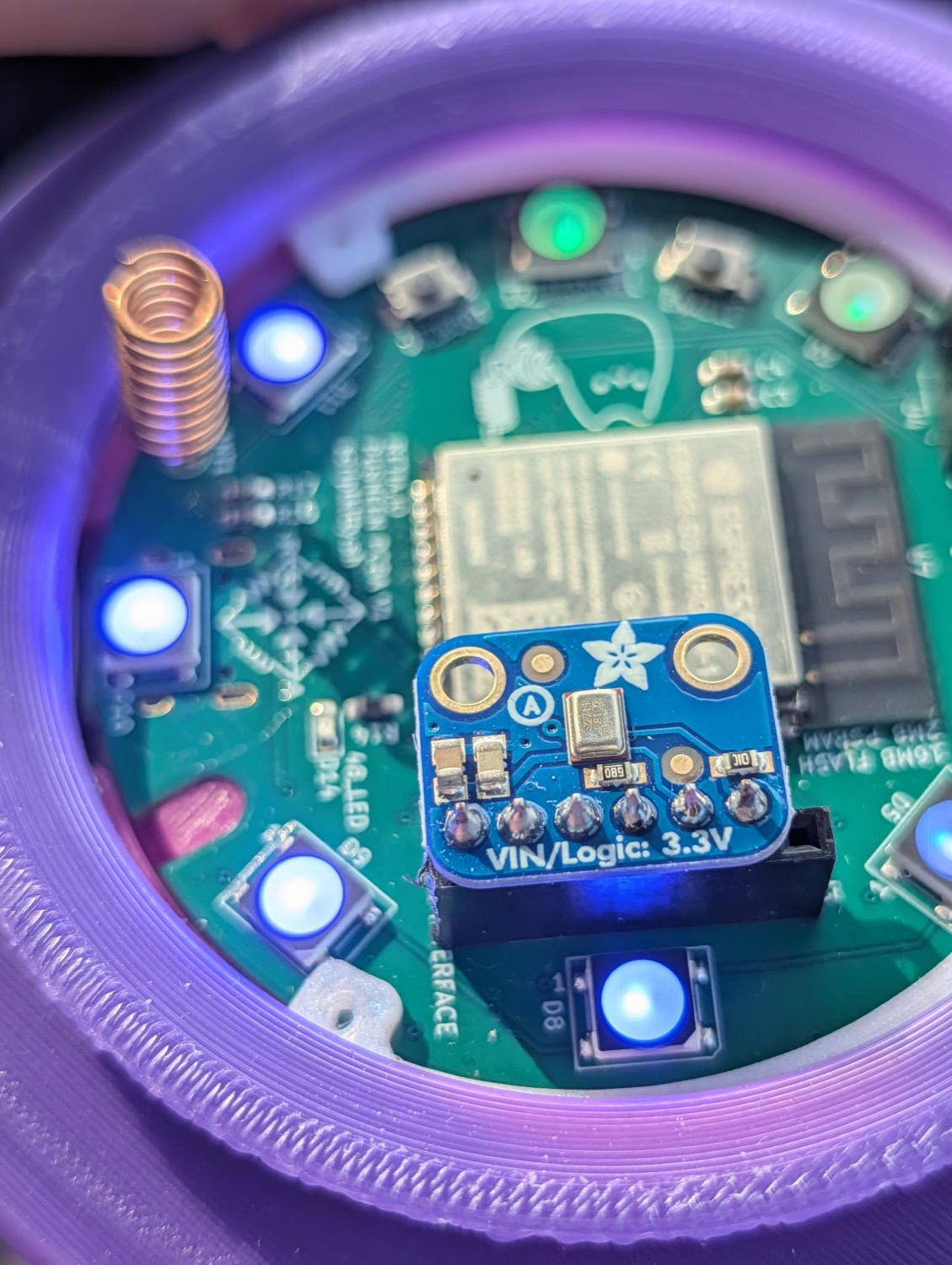 The Newsheen board glowing blue inside its purple 3D-printed base, with the mic and LoRa antenna fitted